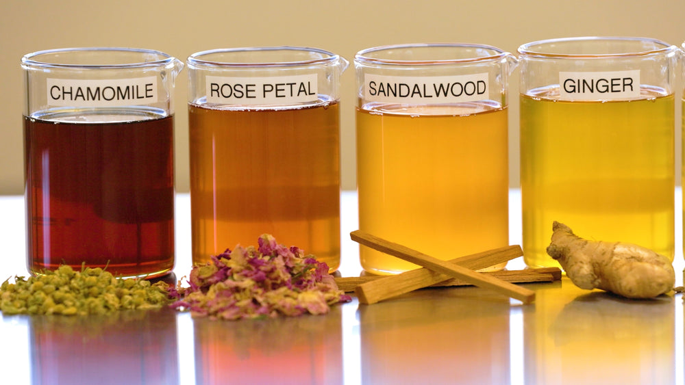 Four glasses with labeled ingredients on a reflective surface.